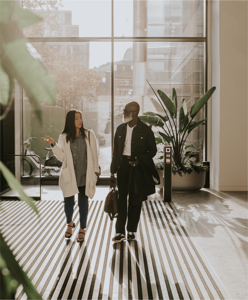 Two professionals walking through an office lobby